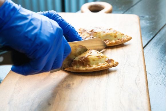 10 Empanadas - Home About Us - Cutting Empanada in half