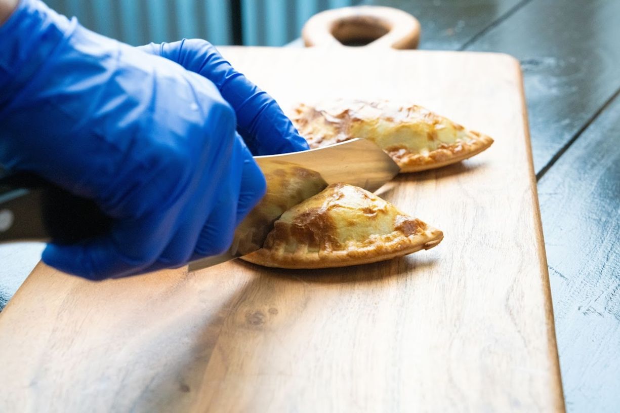 Cutting Empanada in half - 10 Empanadas Delivery
